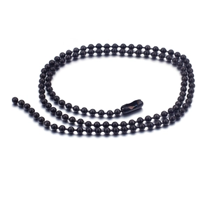 Polished black stainless steel ball chain necklace in coiled layout on white background
