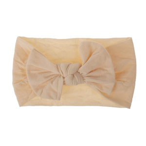 Primo piano di una fascia in morbido nylon color crema per neonati con fiocco