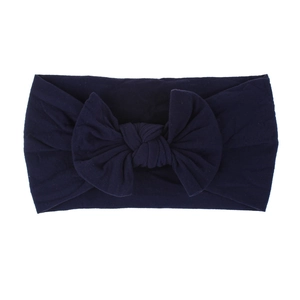 Dettaglio della fascia per neonati in nylon blu scuro con fiocco fatto a mano