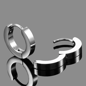 Macro detail of silver stainless steel hinged hoop earrings with polished mirror finish