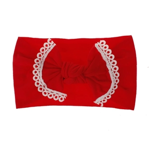 Detailed macro shot of a soft red nylon baby headband featuring a lace-trimmed bow