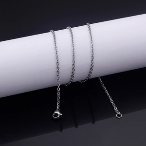 Polished silver stainless steel cross chain necklace wrapped on a white display pillar