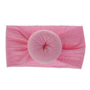 Dettaglio della fascia neonato in nylon rosa morbido con decorazione a nodo elastico