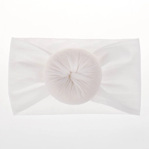 Dettaglio della fascia bianca per neonati in nylon morbido con nodo decorativo a ciambella