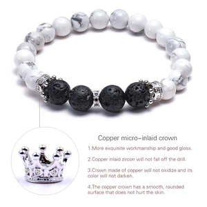Detail of white turquoise and lava stone bead bracelet with a micro-pave crown charm
