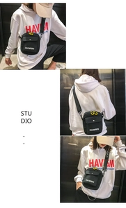 Detail of mini black canvas crossbody bag with yellow loop and adjustable strap