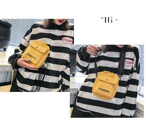 Detail of yellow corduroy crossbody bag with adjustable strap and front pocket