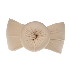 Dettaglio della fascia per neonati in nylon beige morbido con un nodo a ciambella