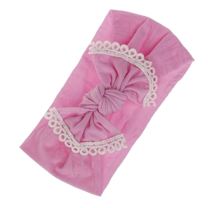 Extra soft pink nylon baby headband featuring a delicate lace-trimmed bow for infants