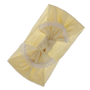 Macro view showing the soft texture and lace bow on this pale yellow baby headband