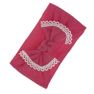 Close-up of rose pink elastic baby headband with soft white lace trim and knotted bow