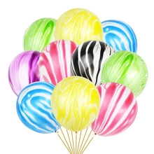 Primer plano de globos de mármol ágata de colores en amarillo azul y rosa para fiesta