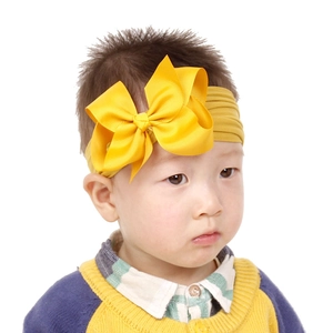 Details des gelben Baby-Haarbandes mit großer Schleife an einem Kleinkindmodell