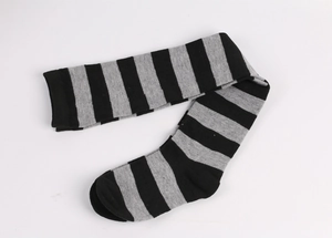 Flat lay of black and grey striped cotton over-knee high socks on a white background