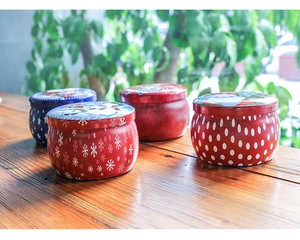 Detailed view of red and blue Christmas tin containers with festive snowflake patterns