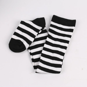 Close-up of black and white striped over-knee socks in a flat lay minimalist display