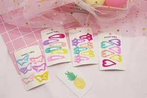 Detail of colorful star and heart-shaped hair clips in pastel tones for kids