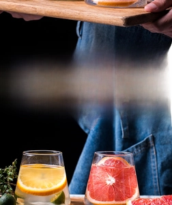 Close-up of heat-resistant Mt. Fuji glass cups with fresh fruit slices on wood tray