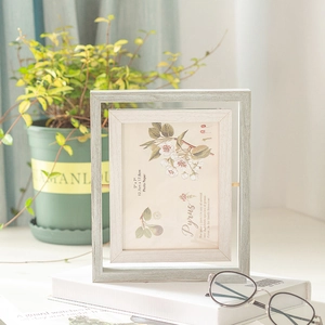 Cadre photo rotatif double face en bois 5x7 avec grain de bois gris clair sur bureau