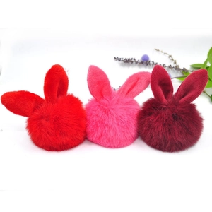 Close-up of cute plush rabbit ear keychains in red and pink colors for women handbags