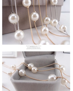 Detail of white pearls on gold and silver snake chains displayed in a velvet jewelry box