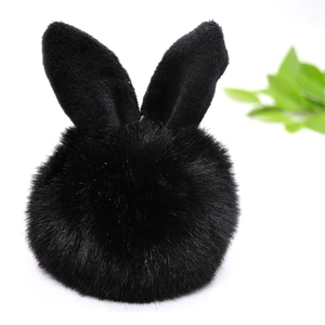Detail of soft black faux fur pompom keychain with cute bunny ears and green leaf accent
