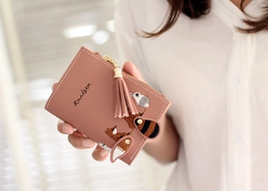 Detail of pink-brown leather short wallet featuring cute embroidered animal and tassel zip