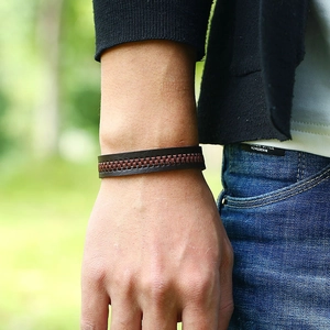 Brown faux leather wristband with decorative zipper worn by male model outdoors