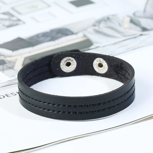 Close-up of black leather bracelet featuring double stitching and silver snap fasteners