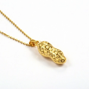 Detailed close-up of 18K gold-plated stainless steel peanut pendant with fine chain texture