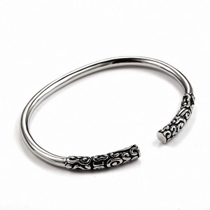 Macro shot of silver titanium steel cuff bracelet with vintage carved pattern detailing