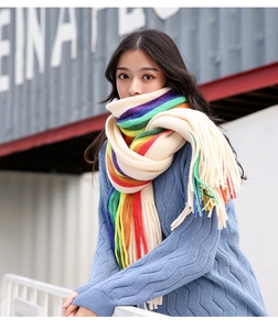 Detailed close-up of colorful rainbow striped knit scarf with long fringes and soft texture