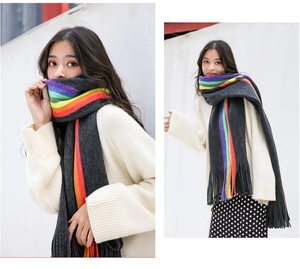 Detail of dark grey scarf with vibrant rainbow stripes and soft fringe tassels