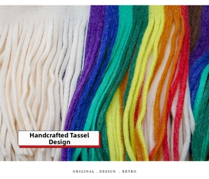Detailed macro view showing rainbow colored hand-twisted tassels on a soft knit scarf