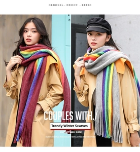 Detailed view of rainbow striped knit scarves with fringe in red and grey color options