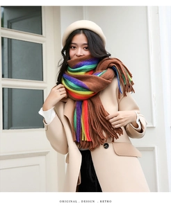 Detail shot of the rainbow striped scarf featuring long fringe and thick knit texture