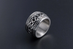 Macro view of vintage titanium steel ring with intricate Celtic knot patterns and aged finish