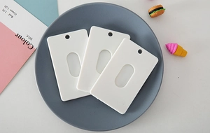 Detailed view of three white ABS plastic card holders with oval slot for DIY printing