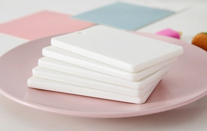Close-up of five white blank ABS plastic card holders with holes on a pink tray