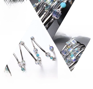 Detail of multi-layered wrap bracelet featuring light blue crystal beads and silver tubes