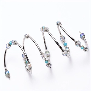 Detailed macro view of spiral multi-layer silver bracelet with crystal and turquoise beads