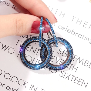 Macro shot of double circle earrings featuring pave-set deep blue rhinestones