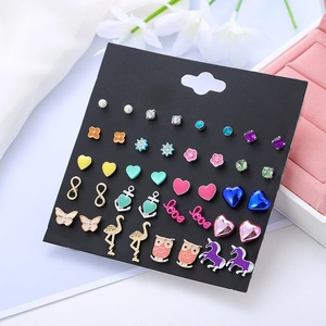 Close-up of gold alloy stud earrings set with unicorn anchor and pearl designs