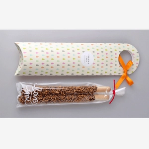 Detailed view of chocolate biscuit sticks in Love you bags with a gift box and ribbon