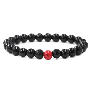 Detail of 8mm black beaded distance bracelet with a red turquoise centerpiece stone