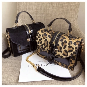 Detail of black suede and leopard print faux fur mini bags with gold chain straps