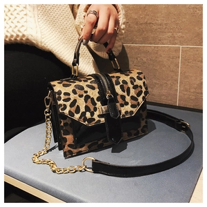 Detail of leopard print crossbody bag with faux fur texture and gold metal chain strap