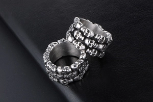 Detailed view of silver skull rings made of titanium steel on black leather background