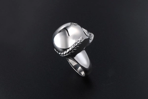 Macro shot of silver vintage skull ring featuring polished stainless steel texture