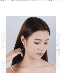 Close-up of elegant silver star tassel earrings worn by a model with rhinestone detail